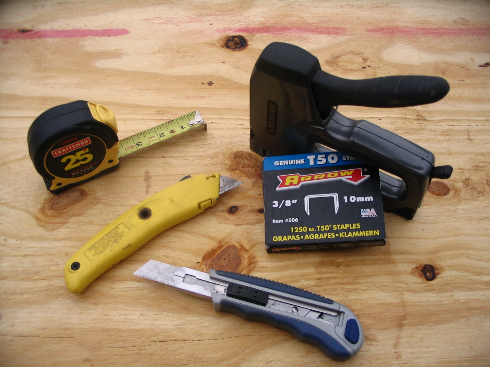 Staple gun, staples, tape measure, and utility knives for radiant barrier installation