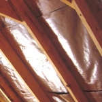 Radiant barrier draped between rafters before new roof decking is fastened